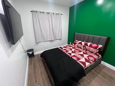 a bedroom with a bed with a green wall at Private Room In Cambridge B4 in Cambridge