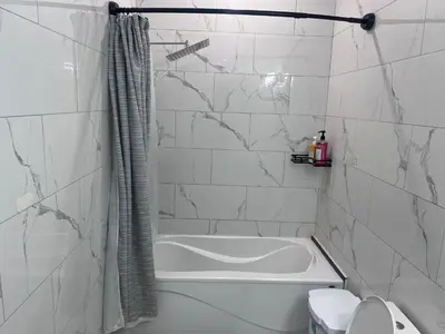 a white bathroom with a tub and a toilet at Private Room In Cambridge B4 in Cambridge