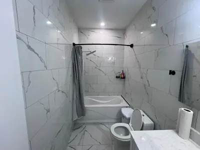 a bathroom with a toilet and a tub and a sink at Private Room In Cambridge B4 in Cambridge