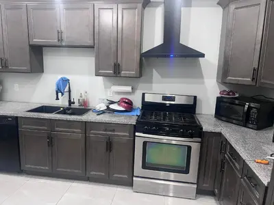 a kitchen with wooden cabinets and a stove top oven at Private Room In Cambridge B4 in Cambridge