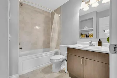 a bathroom with a tub and a toilet and a sink at Cozy 3BR Home with Parking Near Kitchener Attractions in Kitchener