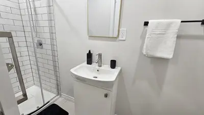 a white bathroom with a sink and a shower at Garden Ave Home 1mins to HWY 403 in Brantford