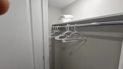 a closet with three hangers on a door at Garden Ave Home 1mins to HWY 403 in Brantford