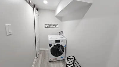 a washer and dryer in a white laundry room at Garden Ave Home 1mins to HWY 403 in Brantford