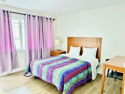 a bedroom with a bed with a colorful blanket at Brant Inn in Brantford