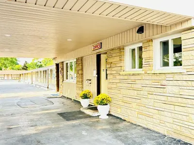 a building with two potted plants in front of it at Brant Inn in Brantford