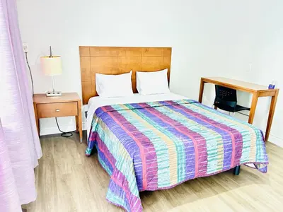 a bed in a room with a desk and a bed sidx sidx sidx at Brant Inn in Brantford