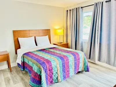 a bedroom with a bed with a colorful blanket at Brant Inn in Brantford