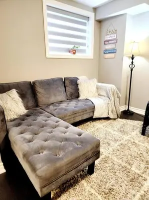 a living room with a couch and a window at 1 Bedroom basement apartment with separate entrance in Milton