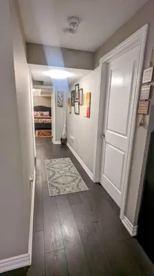 a hallway with a white door and a rug at 1 Bedroom basement apartment with separate entrance in Milton