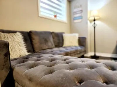 a brown couch in a living room with at 1 Bedroom basement apartment with separate entrance in Milton