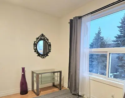 a room with a window with a mirror and a table at Central Downtown Toronto - Trinity Bellwood Park in Toronto