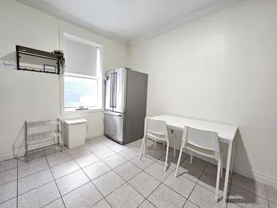 a kitchen with a table and chairs and a refrigerator at Central Downtown Toronto - Trinity Bellwood Park in Toronto