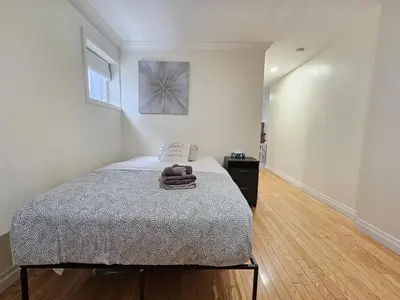 a bedroom with a bed and a picture on the wall at Central Downtown Toronto - Trinity Bellwood Park in Toronto