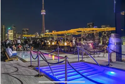 a group of people sitting around a pool at night at Central Downtown Toronto - Trinity Bellwood Park in Toronto