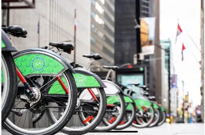 a row of green bikes parked on a city street at Central Downtown Toronto - Trinity Bellwood Park in Toronto