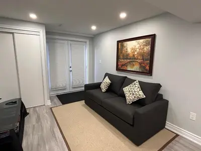 a living room with a couch and a painting on the wall at Rita's Kunjo - 2BR, 3BD, 2WR, Full Ktchn, Living in Whitby