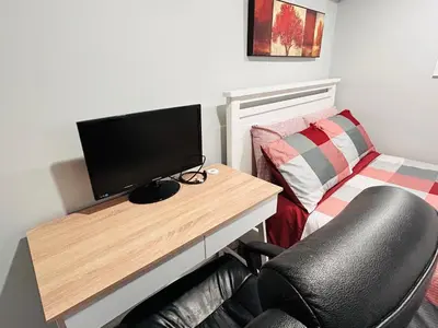 a bedroom with a desk with a computer monitor and a bed at Rita's Kunjo - 2BR, 3BD, 2WR, Full Ktchn, Living in Whitby