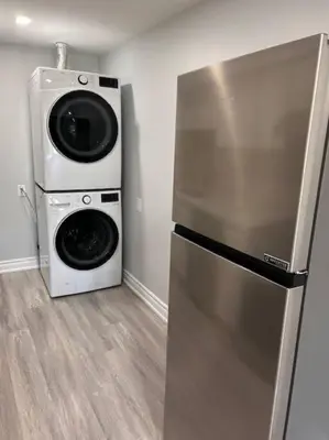 a kitchen with a refrigerator and a washer and dryer at Rita's Kunjo - 2BR, 3BD, 2WR, Full Ktchn, Living in Whitby
