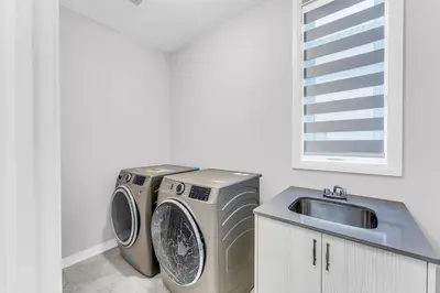 a kitchen with a washing machine and a sink at Executive Brand New House 5 Bedrooms and Office in Cambridge