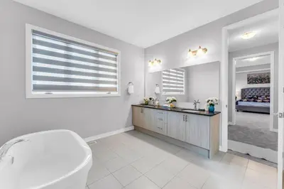 a bathroom with a toilet and a sink and a mirror at Executive Brand New House 5 Bedrooms and Office in Cambridge