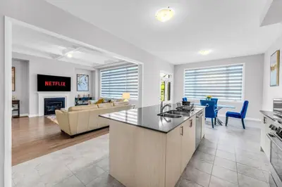 a kitchen and living room with a couch and a table at Executive Brand New House 5 Bedrooms and Office in Cambridge