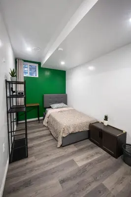 a bedroom with a bed and a green wall at B12 Private Room In Cambridge in Cambridge