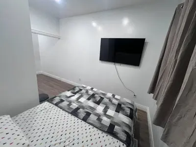 a bedroom with a bed and a flat screen tv on the wall at B12 Private Room In Cambridge in Cambridge