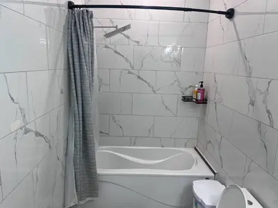 a white bathroom with a tub and a toilet at B12 Private Room In Cambridge in Cambridge