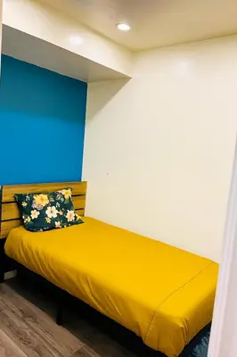 a bedroom with a yellow bed with a blue and white wall at Private Room In Cambridge B8DW in Cambridge