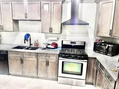 a kitchen with wooden cabinets and a stove top oven at Private Room In Cambridge B8DW in Cambridge