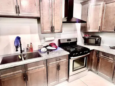 a kitchen with wooden cabinets and a stove top oven at Private Room In Cambridge B8DW in Cambridge