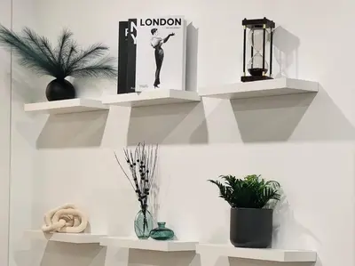 two white shelves on a wall with plants on them at Luxury Stay Near Niagara Falls in Niagara Falls