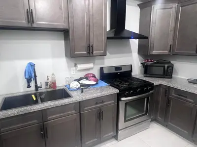 a kitchen with wooden cabinets and a stove top oven at Private Bathroom Room In Cambridge B7 in Cambridge