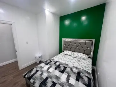 a bedroom with a bed with a green wall at Private Bathroom Room In Cambridge B7 in Cambridge