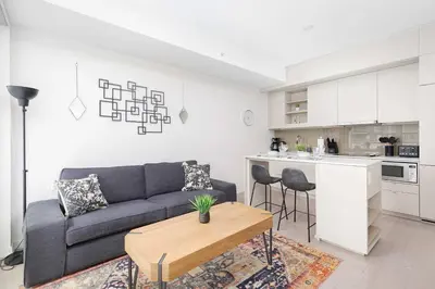 a living room with a couch and a table and a kitchen at 1BR Space - Downtown Toronto in Toronto