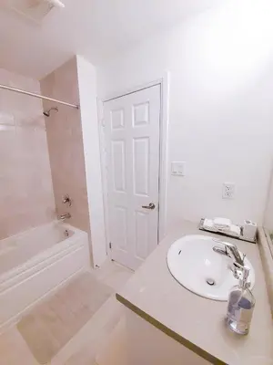 a white bathroom with a sink and a tub at New 3-BR Home Near Niagara Falls with King Bed 75 Inch TV and Free Parking in Thorold