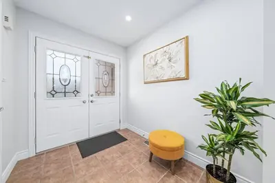 a hallway with a door and a stool and a plant at Stylish and Cozy 4 bedroom House in Barrie