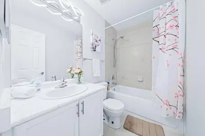 a white bathroom with a sink and a toilet and a shower at Stylish and Cozy 4 bedroom House in Barrie