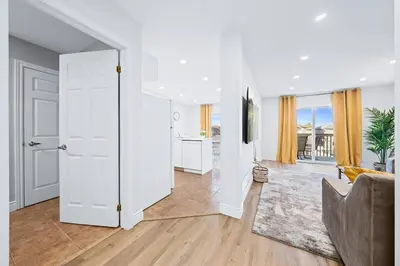 a living room with a white door and a couch at Stylish and Cozy 4 bedroom House in Barrie