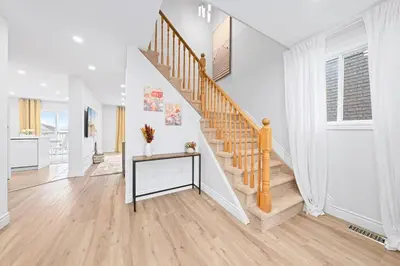 a white hallway with a staircase in a house at Stylish and Cozy 4 bedroom House in Barrie