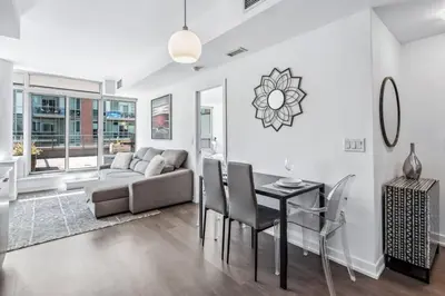 a living room with a couch and a table and chairs at Stylish 2BR Urban Escape, BBQ, Private Terrace in Toronto