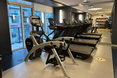 a gym with a row of treadmills and machines at Stylish 2BR Urban Escape, BBQ, Private Terrace in Toronto