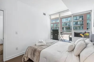 a bedroom with a large bed and a large window at Stylish 2BR Urban Escape, BBQ, Private Terrace in Toronto
