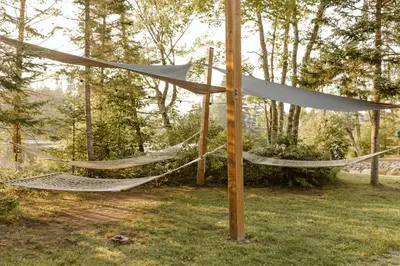 a pair of hammocks in a yard with trees at Wolegib Waterfront Retreat in Muskoka in Huntsville