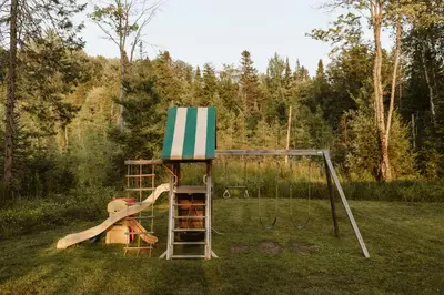 a play set in a yard with a swing at Wolegib Waterfront Retreat in Muskoka in Huntsville