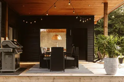 a patio with a table and chairs and a grill at Wolegib Waterfront Retreat in Muskoka in Huntsville