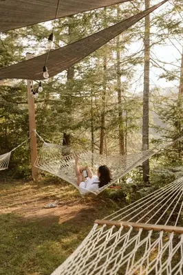 a woman laying in a hammock in the woods at Wolegib Waterfront Retreat in Muskoka in Huntsville