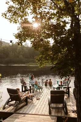 a group of people sitting on a dock by the water at Wolegib Waterfront Retreat in Muskoka in Huntsville
