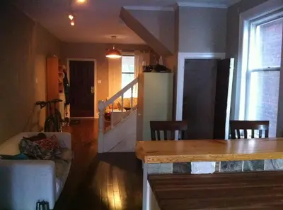 a kitchen and living room with a table and a refrigerator at Lovely home in Leslieville in Toronto